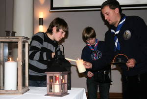Friedenslicht Kind Lukas Klleinwächter übergibtt im Geraer Rathaussaal das Licht an die Pfadfinder Clemens Riese und Udo Wich Heiter.